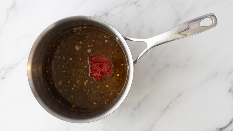 pan drippings and tomato paste in saucepan