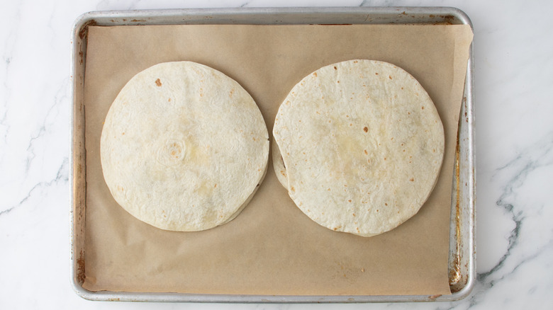 stacked tortillas on baking sheet