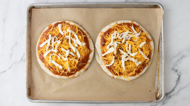 two tortillas topped with sauce and cheese