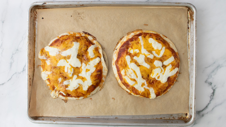 two baked tortilla pizzas