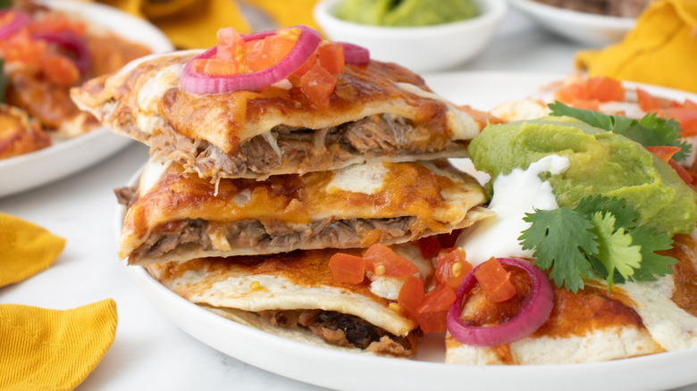 closeup stacked slices of Mexican pizza with garnishes