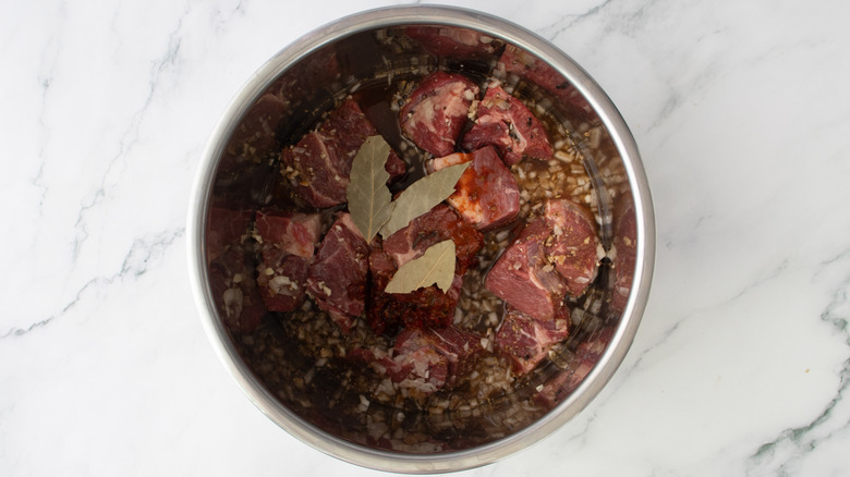 beef chunks with seasonings in slow cooker