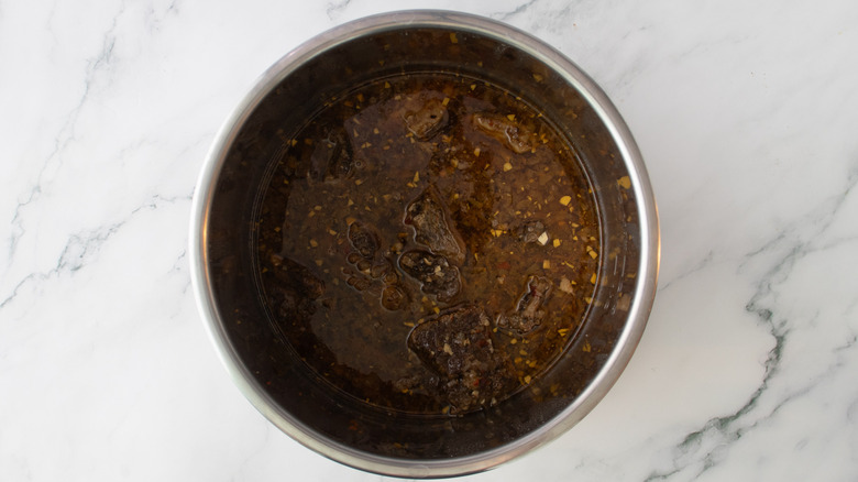 cooked beef with broth in slow cooker