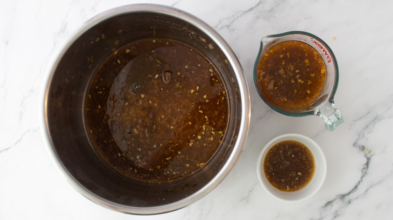 cups with pan drippings next to slow cooker