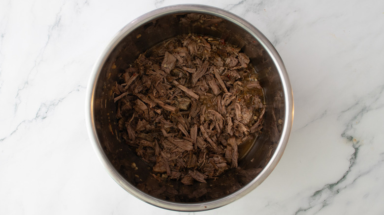 shredded beef in slow cooker with pan drippings
