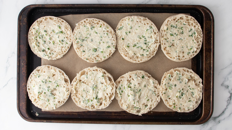 buttered english muffins in a baking pan