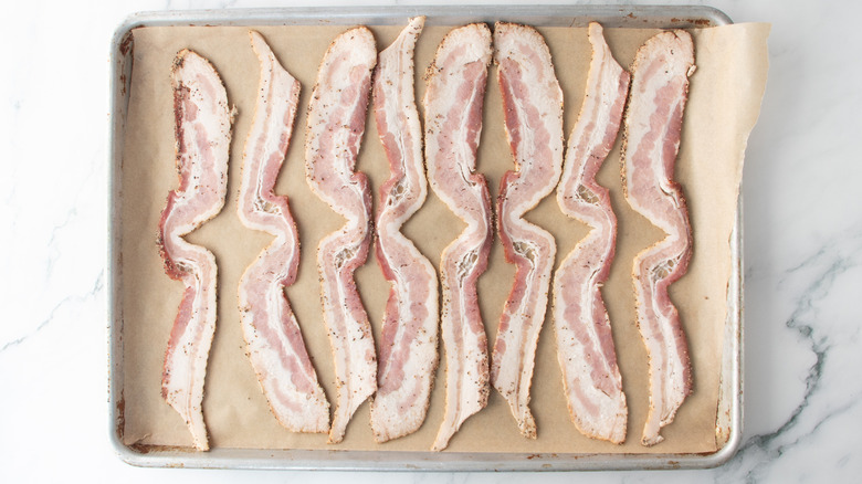 raw bacon in a baking pan