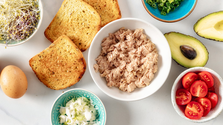 Tuna with bread, avocado, and other toppings
