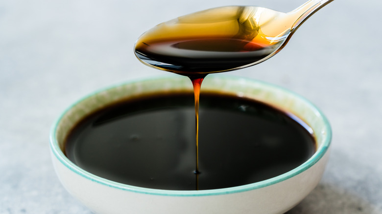 A small white bowl of dark syrup.