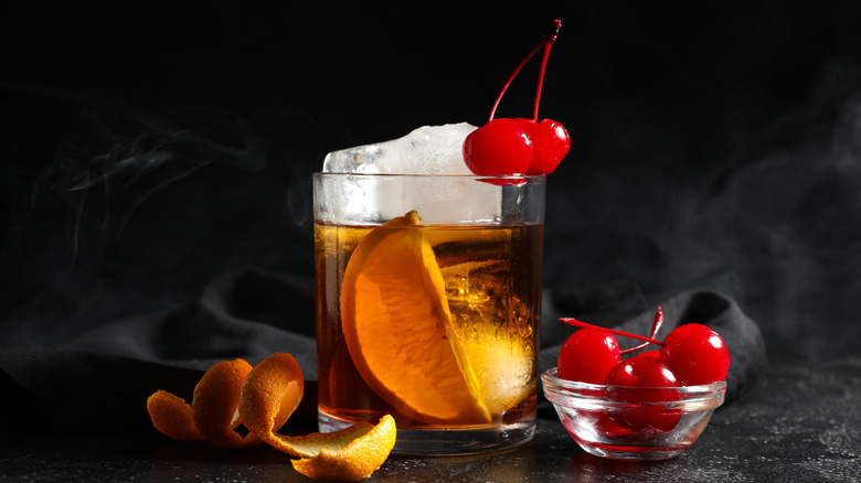 An old fashioned garnished with orange slice and cherries