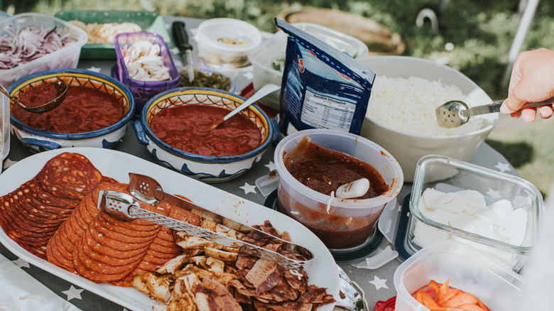 open containers of pizza toppings outdoors
