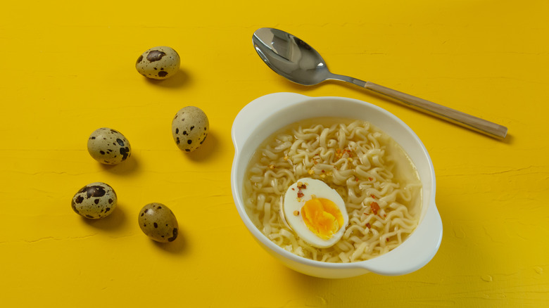 Instant ramen with quail eggs on yellow table
