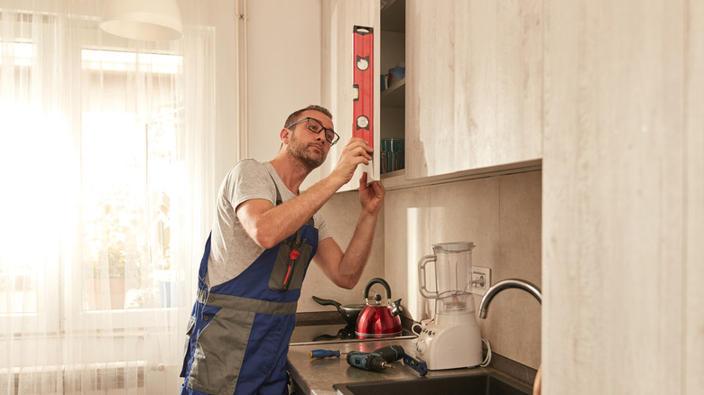 Man measuring kitchen cabinet doors