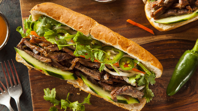 A bánh mì sandwich on a cutting board.