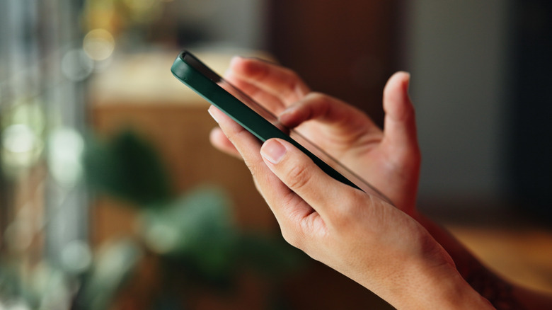 Hands typing on cell phone