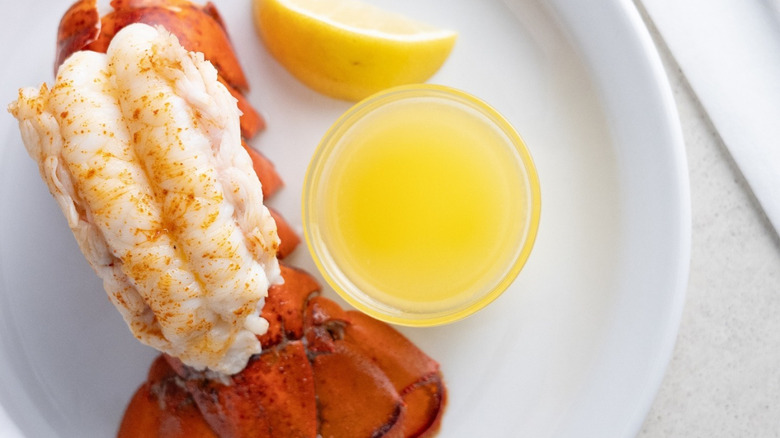 Overhead view of a Golden Corral lobster tail with a dish of melted butter and a lemon wedge