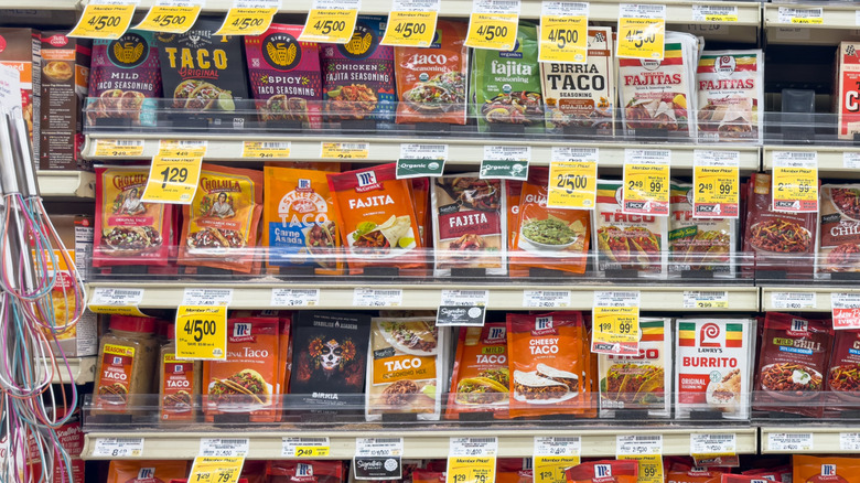 Packets of taco seasoning on shelves in a grocery store aisle