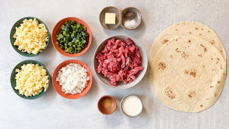 Gooey cheesesteak quesadilla ingredients on countertop