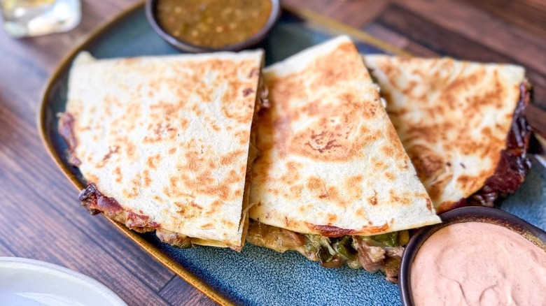 Gooey cheesesteak quesadillas on servign platter close up
