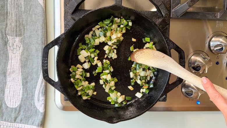 Sauteing chopped onion and poblano pepper in cast iron skillet on stovetop