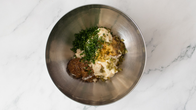 assorted condiments and seasonings in a metal bowl