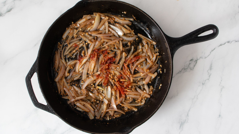 cooked garlic and shallots in a black frying pan