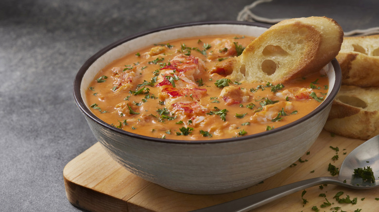 white bowl of lobster bisque with bread garnish