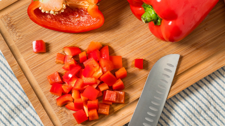 Chopped bell pepper on a cutting board next to a knife