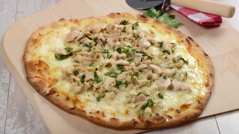 Clam-topped pizza on a wooden cutting board