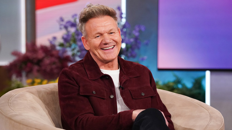 Gordon Ramsay sitting on a chair smiling