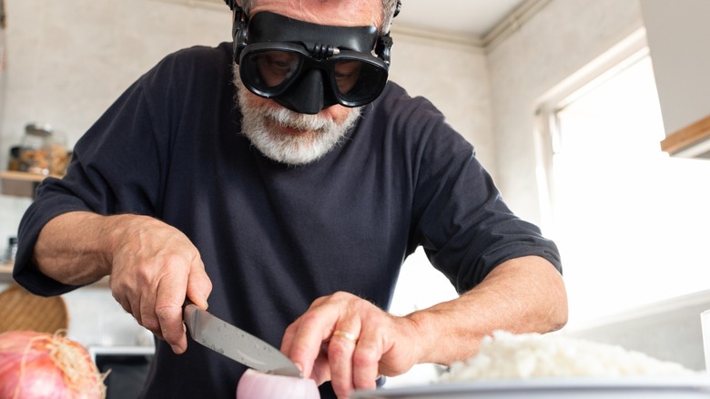 a man in a diving mask slicing onions