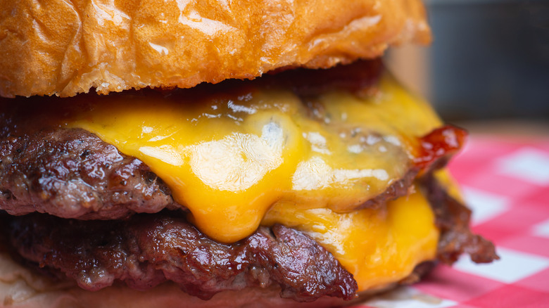 An enticing cheeseburger is photographed in closeup.