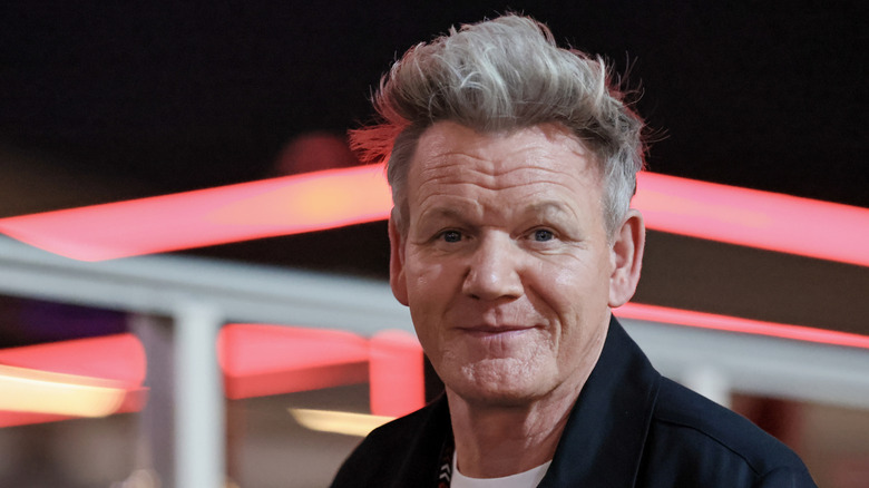 Close-up of Gordan Ramsay with red neon lights blurred in background