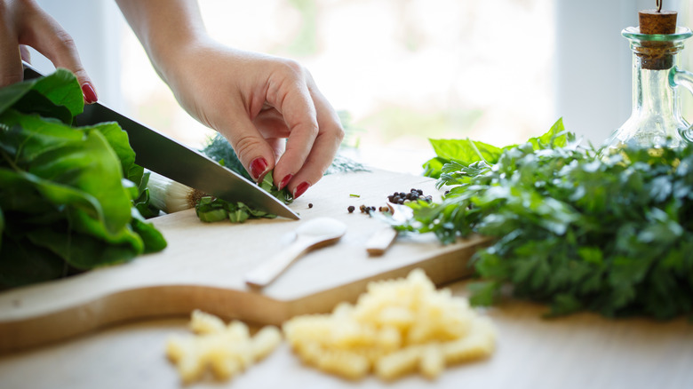 hand chopping fresh basil