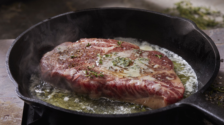 Ribeye steak cooking in butter