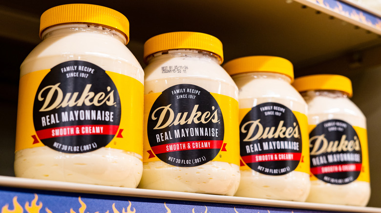 A row of large Duke's Real Mayonnaise jars on a supermarket shelf