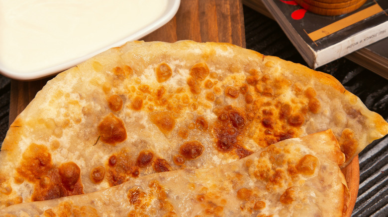 Folded quesadillas with crispy cheese edges and a side of crema