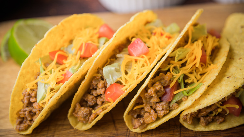 hard shell tacos with cheese, meat, and lettuce