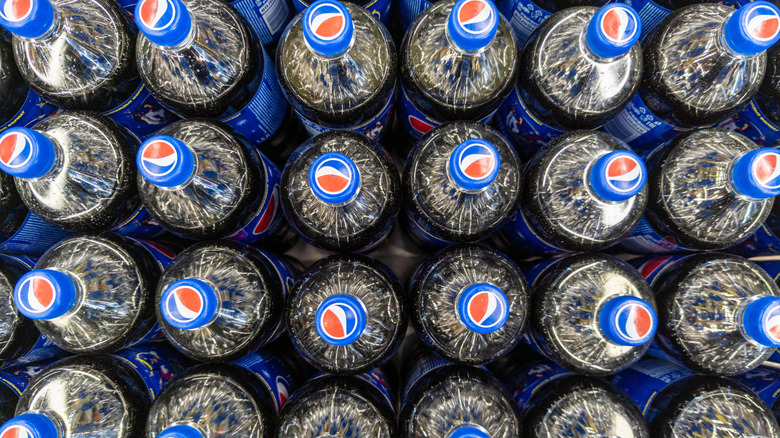 A pallet of Pepsi bottles seen from above, their bottle caps prominently visible