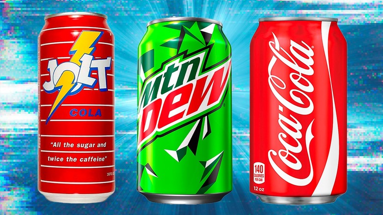 Jolt Cola, Mountain Dew, and Coca Cola cans on blue backdrop