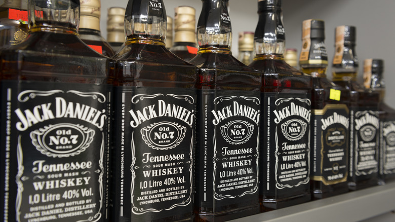 Bottles of Jack Daniel's Old No. 7 in a row on a shelf.