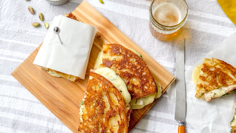 Grilled Italian picnic sandwiches on cutting board  with knife and beer