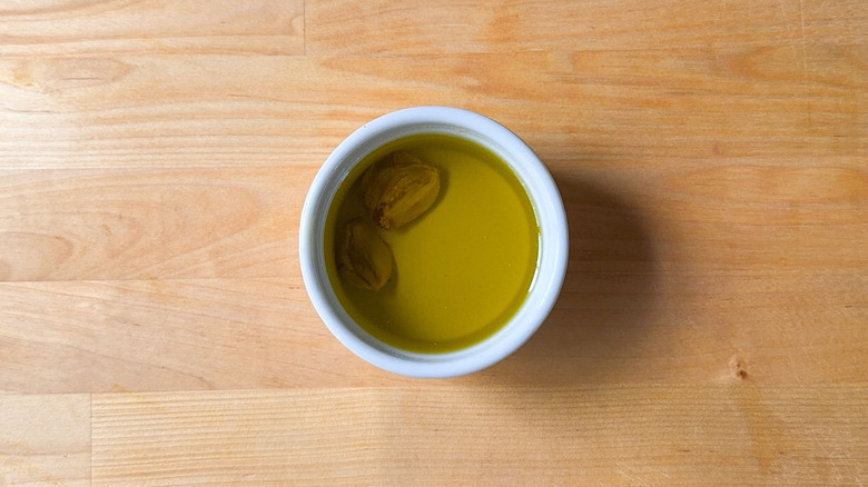 Garlic cloves in olive oil in ramekin