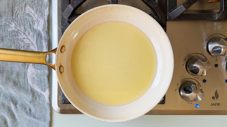 Avocado oil heating in skillet on stovetop