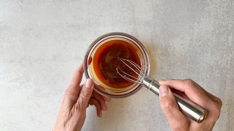 Whisking mushroom marinade in small glass bowl