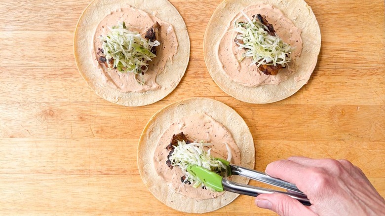 Adding slaw to grilled oyster mushroom clusters