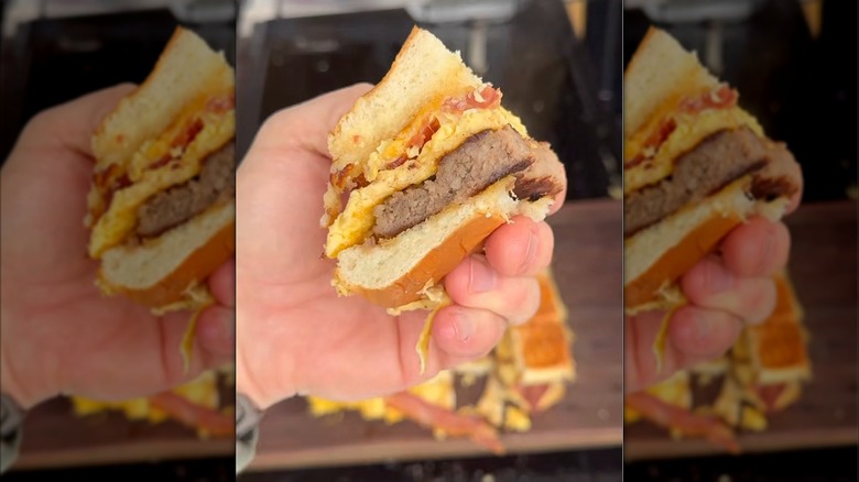Hawaiian roll breakfast sandwiches held in a hand