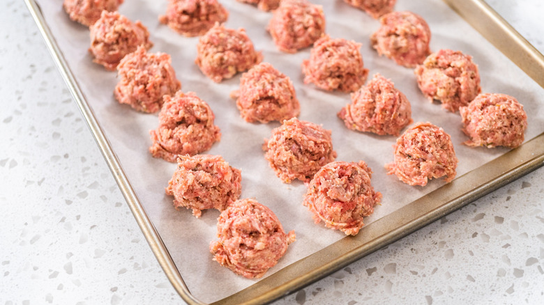 Ground beef meatballs on baking sheet lined with parchment paper