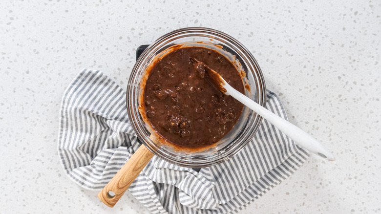 Chunky chocolate fudge being mixed on a double boiler