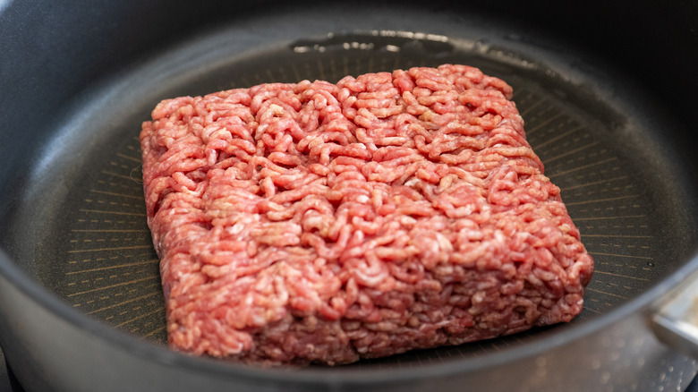 Block of ground beef in a black pan